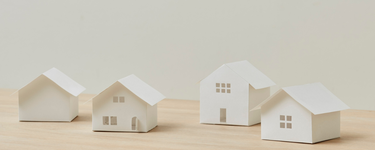 White paper house models on a wooden surface